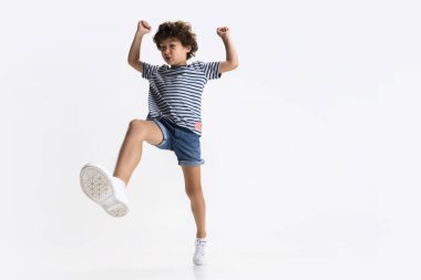 Beyaz stüdyo arka planında izole edilmiş küçük anaokulu çocuğunun portresi.