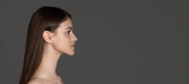 Gri stüdyo arka planında izole edilmiş güzel gülümseyen beyaz bir kızın portresi olan el ilanı..