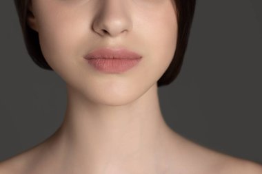 Gri stüdyo arka planında izole edilmiş güzel bir kadın yüzü resmi..