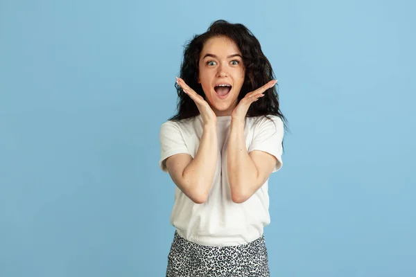 Wow, asombrado. Retrato de una joven hermosa mujer caucásica rizada posando aislada sobre fondo de estudio azul claro. —  Fotos de Stock