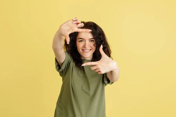 Una joven y alegre mujer caucásica posando aislada sobre fondo amarillo del estudio. Concepto de emociones humanas, expresión facial —  Fotos de Stock