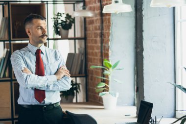Portrait of young businessman, office worker, manager at office. Concept of business, work days, sales, ad.