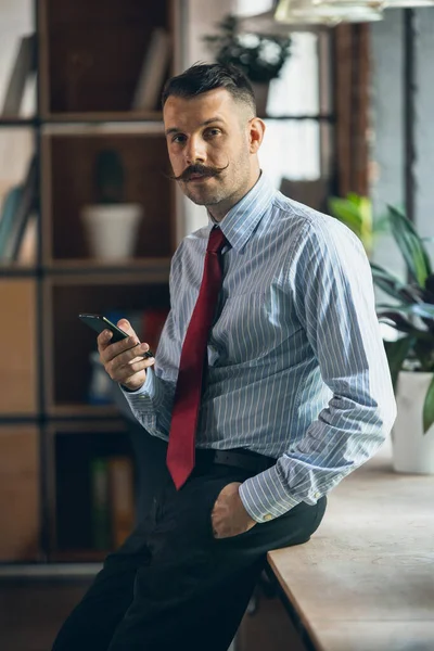 One young businessman, office worker, manager with smartphone. Modern office interior. Vertical portrait — Foto de Stock
