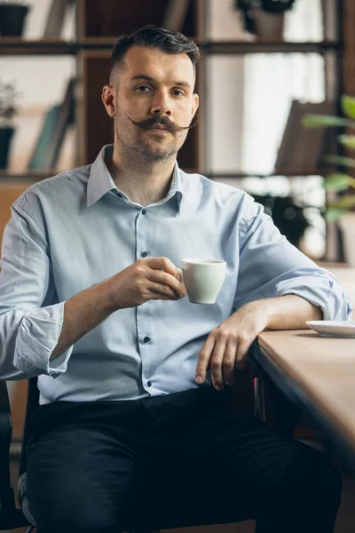 One young businessman, office worker, manager sitting on chair with cup of coffee. Business, working process concept. — Fotografia de Stock