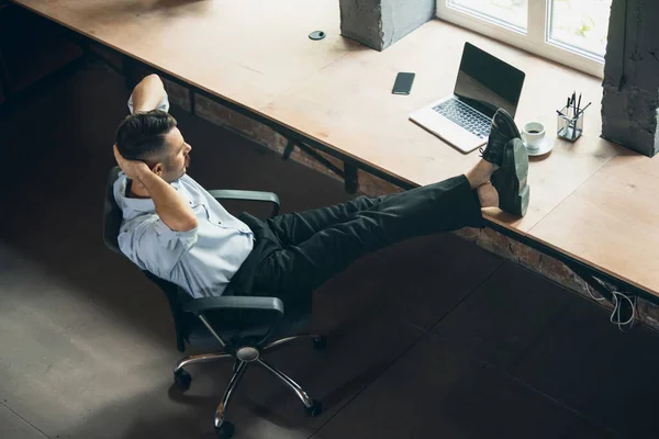 Making a break in working process. One young businessman, office worker having a rest at his workplace. View from above — Fotografia de Stock