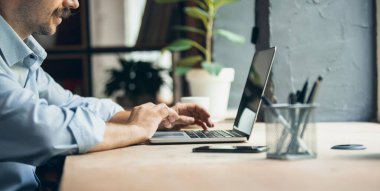 Flyer with image of one young businessman, manager working on laptop, typing text. Side view.