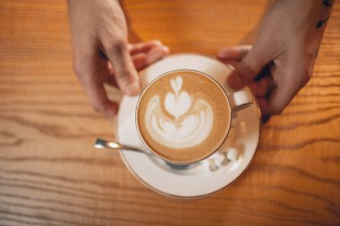 View from above. White cup of coffee, latte or cappuchino with marshmallow on wooden bar counter in cafe.