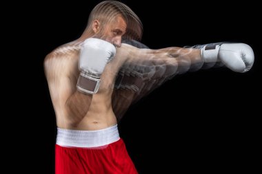 Kırmızı şortlu ve eldivenli genç bir profesyonel boksör, siyah stüdyo arka planında egzersiz yapıyor..