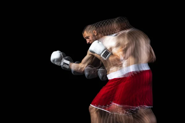 Jonge professionele bokser in rode shorts training, oefenen over zwarte achtergrond. Stroboscoop-effect — Stockfoto