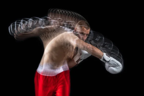 Fiatal profi férfi bokszoló piros rövidnadrágban és boksz kesztyű képzés, gyakorló fekete háttér. Sztroboszkóp — Stock Fotó