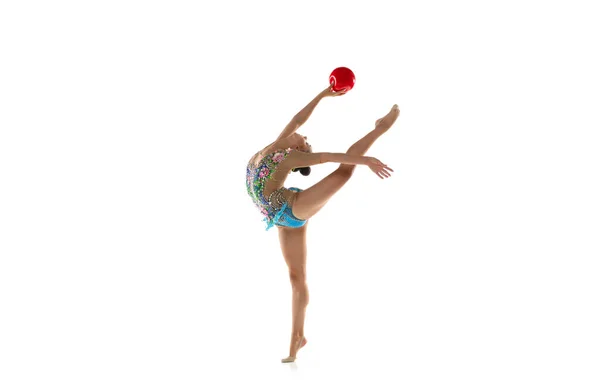 Eine junge flexible rhythmische Turnerin mit rotem Ball in Bewegung und Aktion isoliert auf weißem Studiohintergrund. — Stockfoto