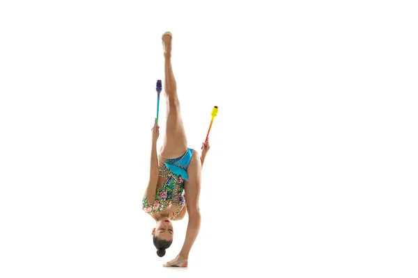 Bir bayan ritmik jimnastikçi hareket halindeki sopalarla ve beyaz arka planda izole edilmiş hareketlerle. — Stok fotoğraf
