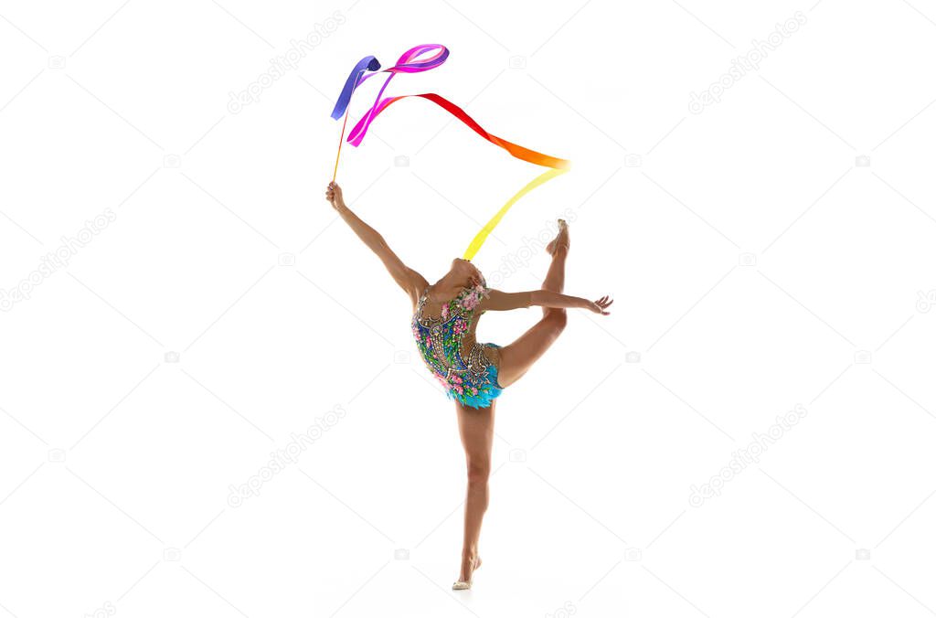 Young beautiful girl, rhythmic gymnast with colored ribbon in motion isolated on white studio background.