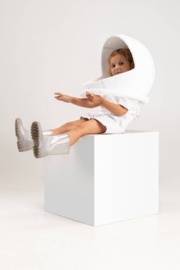 Beyaz stüdyo arka planında izole edilmiş, büyük kasklı, küçük şirin bir anaokulu kızının stüdyosu fotoğrafı..