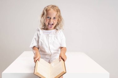 Beyaz stüdyo arka planında dilini soyutlayan beyaz, beyaz, beyaz, beyaz bir kızın resimlerini çekiyoruz..