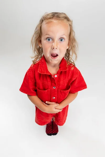 Portret małej białej dziewczyny w czerwonym romper pozowanie izolowane na białym tle studio. — Zdjęcie stockowe