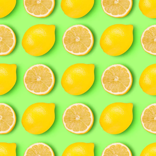 Limones locos. Mitades y limones amarillos jugosos enteros dispuestos sobre un vibrante fondo verde claro. — Foto de Stock