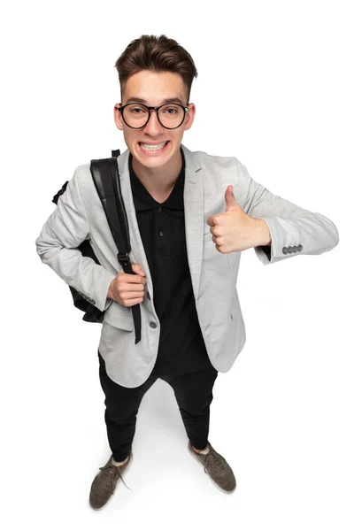 Vertical image of young caucasian guy, student in grey jacket with backpack isolated over white studio background. — Stock Photo, Image