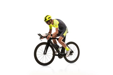 Side view. One professional male cyclist on road bike turning to the side isolated over white studio background.