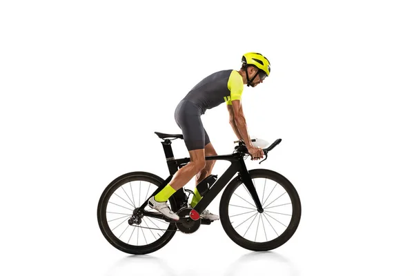 One professional male cyclist on road bike isolated over white studio background. Side view — Stockfoto