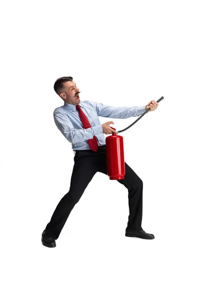 Putting out the fire. Portrait of young Caucasian man, office worker with extinguisher isolated over white background. — Stock Photo, Image