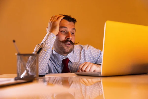 Cansado de trabalho. Um jovem caucasiano, trabalhador de escritório sentado em seu local de trabalho em fundo branco. — Fotografia de Stock