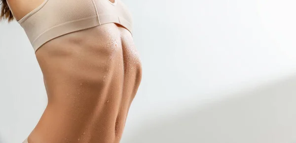 Крупный план. Обрезанное стройное женское тело в бежевом нижнем белье изолировано на белом фоне студии. Flyer — стоковое фото