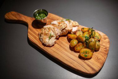 Tahta bir tahtanın üzerinde servis edilen et yemeğinin yakın plan görüntüsü. Soslu et ve kızarmış patates. Yukarıdan görüntüle