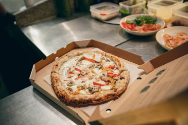 Yakın plan. Lezzetli, sıcak, yuvarlak vejetaryen pizzayı karton bir kutuda. Lezzetli, aromatik ve iştah açıcı görünüyor..