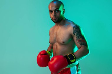 Ön manzara. Profesyonel bir boksör, elleri mavi yeşil arka planda, neon ışıkta yan yana duruyor. El ilanı