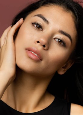 Yakın plan portre. Siyah elbiseli güzel beyaz kadın kahverengi stüdyo arka planında izole edilmiş..