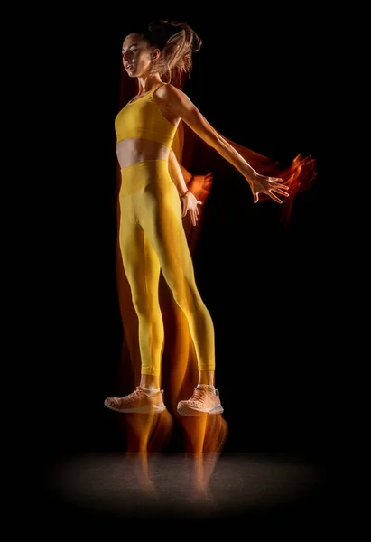 Retrato vertical de atleta profissional feminino faixa isolada sobre fundo estúdio preto em luzes de néon mistas. — Fotografia de Stock