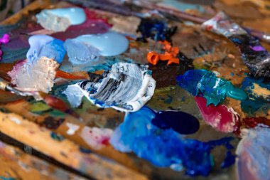 Stüdyoda ya da arka planda boya fırçası ve palet bıçağıyla yakın çekim paleti.