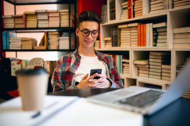 Genç bir Kafkasyalı, evinde ya da kütüphanesinde dizüstü bilgisayarı olan bir öğrenci..