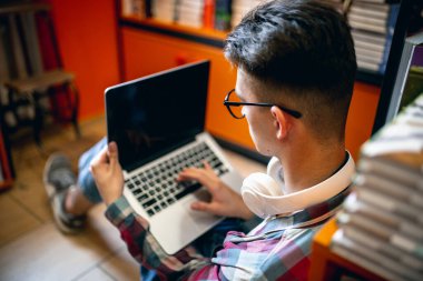 Genç bir Kafkasyalı, evinde ya da kütüphanesinde dizüstü bilgisayarı olan bir öğrenci..