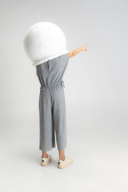 Beyaz stüdyo arka planında izole edilmiş büyük kasklı küçük beyaz okul kızı portresi..