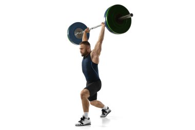 Beyaz arka planda izole edilmiş bir ağırlıkla spor kıyafetli bir adamın tam boy portresi.