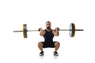 Beyaz arka planda izole edilmiş bir ağırlıkla spor kıyafetli bir adamın tam boy portresi.