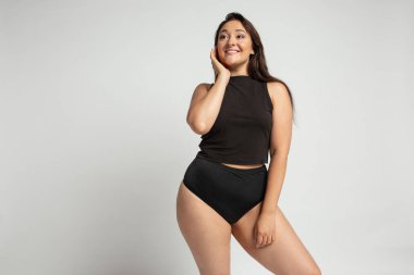 Beyaz arka planda pamuklu iç çamaşırlı, güzel, tombul bir kadın.