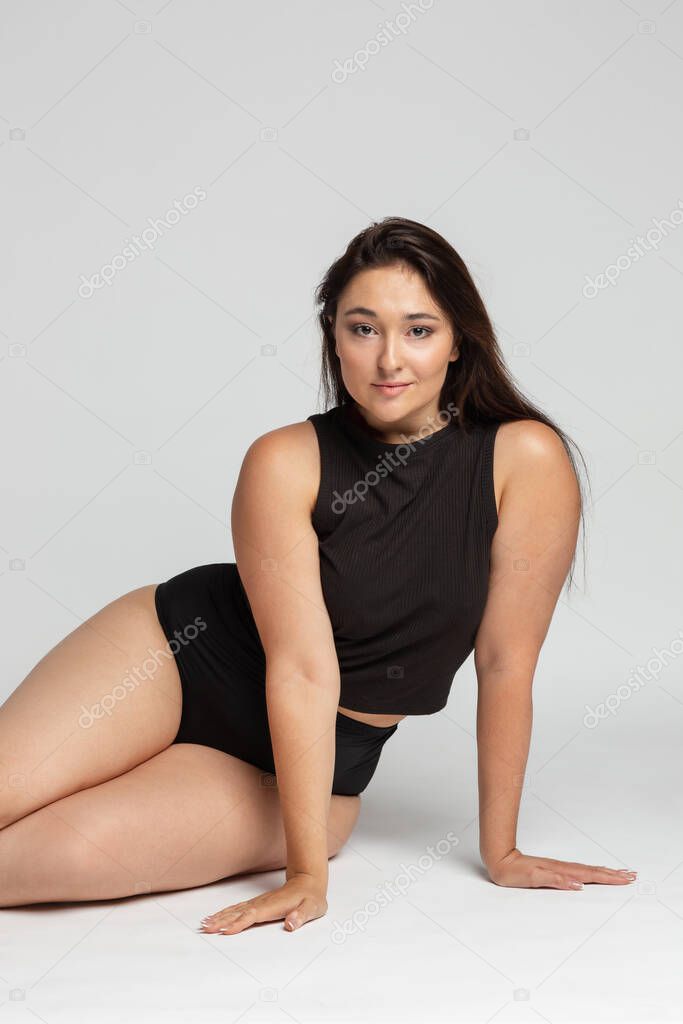 Young beautiful plump woman in cotton underwear on white background