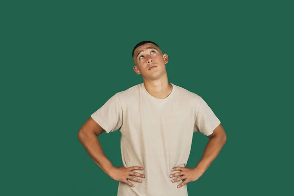 Retrato de jovem bonito asiático homem em t-shirt isolado sobre escuro verde estúdio fundo. — Fotografia de Stock