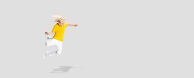 El ilanı. Küçük tatlı kıvırcık okul çocuğu eğleniyor, beyaz stüdyo arka planında soyutlanmış oynuyor..