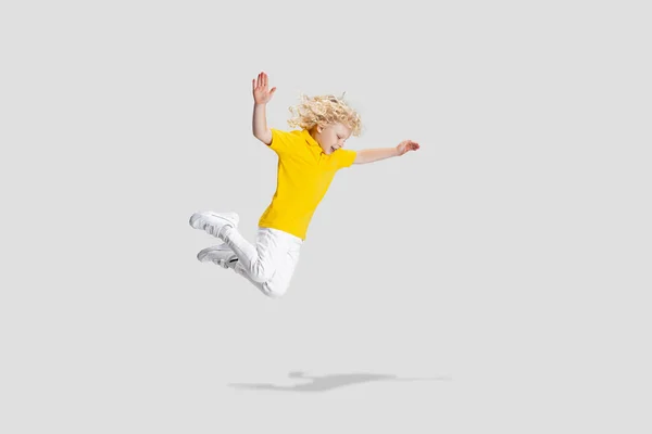 Χαριτωμένο μικρό σγουρό παιδί προσχολικής ηλικίας που διασκεδάζει, παίζει απομονωμένο σε λευκό φόντο στούντιο. — Φωτογραφία Αρχείου