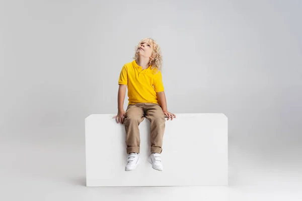 Πορτρέτο του ένα χαριτωμένο μικρό σγουρό παιδί προσχολικής ηλικίας σε casual ρούχα απομονώνονται σε λευκό φόντο στούντιο. — Φωτογραφία Αρχείου