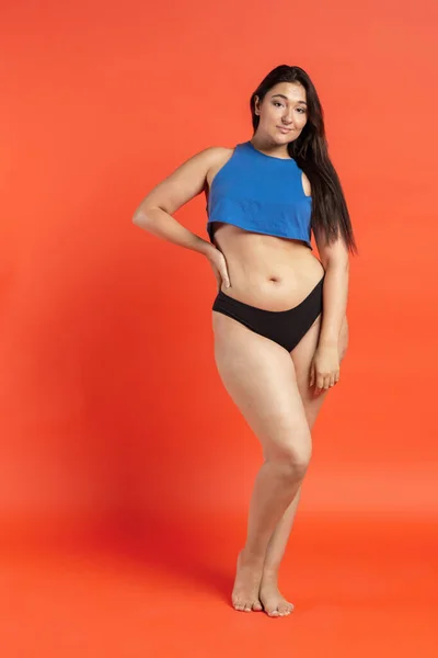 Jovem bela mulher gorda em roupa interior de algodão no fundo laranja — Fotografia de Stock