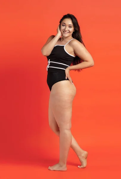 Jovem bela mulher gorda em roupa interior preta no fundo laranja — Fotografia de Stock