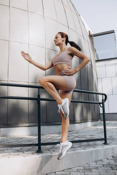 Jovem magro esportivo caucasiano mulher trabalhando fora, fazendo fitness, ioga na rua da cidade. — Fotografia de Stock