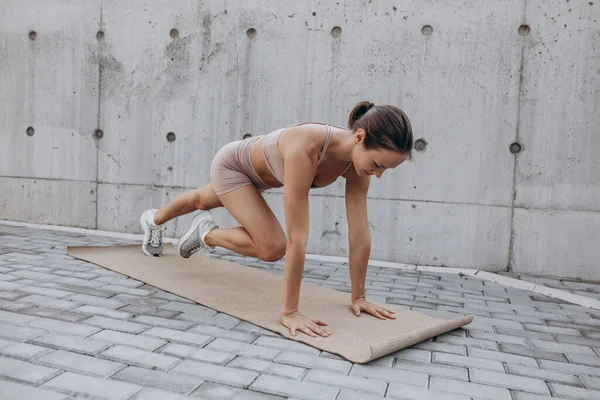 One young slim sportive caucasian woman working out, doing fitness, yoga on the city street. — Stock Photo, Image