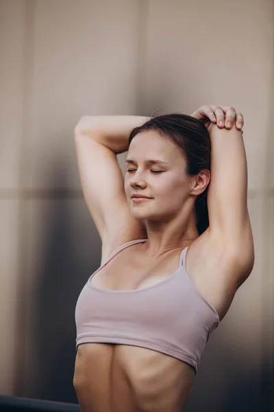 Une jeune femme caucasienne sportive mince échauffement, faire du fitness, yoga dans la rue de la ville. — Photo