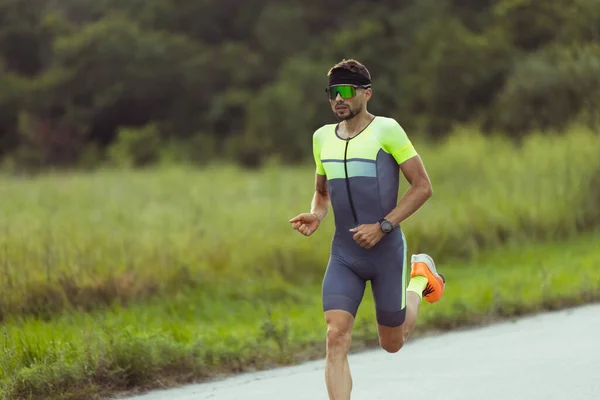 Junger männlicher Triathlet, Läufer in Bewegung auf offener Straße. Konzept von Sport, Lifestyle, Aktivität — Stockfoto